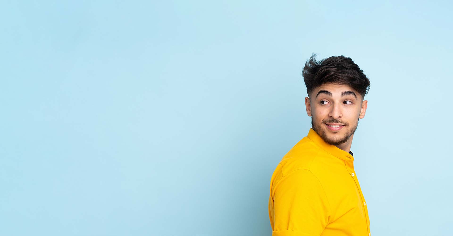 Man in yellow shirt on light blue background